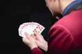 Magician shows trick with playing same cards on dark background. Disclosure of focus Royalty Free Stock Photo