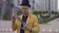 Magician in yellow jacket and hat has fun with playing cards