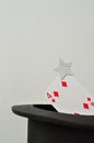 A magicians hat displayed with a four of diamond card
