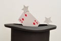 A magicians hat displayed with a four of diamond card