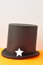 A magicians hat displayed with one silver glitter star