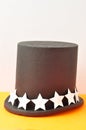 A magicians hat displayed with a row of silver glitter stars
