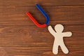 Magnet and paper person on wooden table