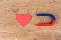 Magnet and red heart on wooden table, flat lay