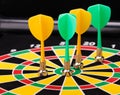 Magnetic dart arrows on dart board. black background Royalty Free Stock Photo