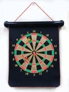 Magnetic dartboard with darts hanging from white office wall. Royalty Free Stock Photo