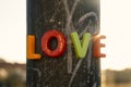 Magnetic letters forming the word love stuck on a street lamp with the sun behind it. Valentine\'s day concept