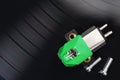 Magnetic phono cartridge and screws on vinyl record