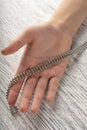 Magnetic toy made of metal balls in the hand of a teenager on a background of a wooden black and white table