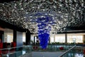 A magnificent chandelier of glass in the form of many fish in the interior of a modern hotel