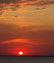 Magnificent dreamy sunset over the water surface of lake on background of setting sun and colorful clouds Royalty Free Stock Photo