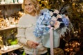 Magnificent floral arrangement of aster, roses and hydrangea, orchids in box in hands of woman Royalty Free Stock Photo