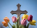A cross with multicolor tulips around, light blue sky background, Easter holiday symbol, church, generative AI