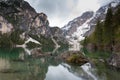 Magnificent lake Lago di Braies. The emerald smooth surface of water reflects the wood and mountains around Royalty Free Stock Photo