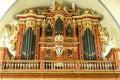 Magnificent large church organ with many pipes and registers in golden and brown color