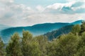 A magnificent panorama of blue mountains with a beautiful misty landscape. Top view of treetops, mountain range and sky with