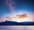 Magnificent panorama of sunrise over the sea. Vibrant night sky with stars and nebula and galaxy. Deep sky astrophoto Royalty Free Stock Photo