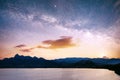 Magnificent panorama of sunrise over the sea. Vibrant night sky with stars and nebula and galaxy. Deep sky astrophoto Royalty Free Stock Photo