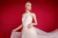 A magnificent photo of a graceful girl in a white dress on a red. A modern photo of an elegant bride in a classic retro style.