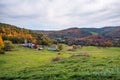 Magnificent rolling rural landscape with a farm at the foot of a wooded hill at the peak of fall foliage colours Royalty Free Stock Photo