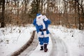 Magnificent snow covered landscape Santa Claus in blue suit on the fairy winter forest