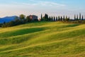 Magnificent spring landscape at sunrise.Beautiful view of typical tuscan farm house, green wave hills.