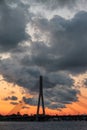 Magnificent sunset over the Daugava river and the Vansu or Suspension bridge in Riga, Latvia. Colorful clouds and warm skylight Royalty Free Stock Photo