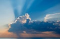 Magnificent sunset over sea. Sun covered by picturesque cloud with beautiful shine sun beams in sky Royalty Free Stock Photo