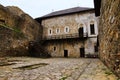 Magnificent view of courtyard with ancient stone building in the medieval castle. High stone wall with tower in the background. Royalty Free Stock Photo