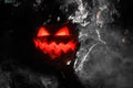 magnificent view on glowing handmade halloween pumpkin with smoking mouth and eyes which woman holds. Jack-o-lantern