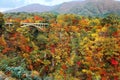 Magnificent view of a highway bridge spanning across Naruko Gorge with colorful autumn foliage on vertical rocky cliffs in Royalty Free Stock Photo