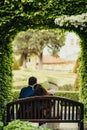 The magnificent view of the newlywed couple spending time in the garden. Just married are sitting on the bench under the Royalty Free Stock Photo