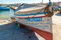 Marsaxlokk, Malta, August 2019. Fishing boat under a canvas cover, pulled ashore.