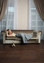 Magnificient woman resting on brown sofa indoor