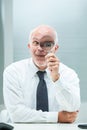 Magnified view, businessman jests, encourages search Royalty Free Stock Photo