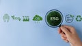 Magnifier focuses on Earth's ESG icon for developing green energy concepts. ESG Environmental, environmental, social, and