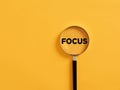 Magnifier focuses on the word focus. glass. Focusing or concentration on an issue in business or education Royalty Free Stock Photo