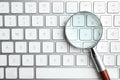 Magnifier glass on modern keyboard. Find keywords concept Royalty Free Stock Photo