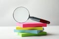 Magnifier glass and stack of colorful memory stickers on white table. Find keywords concept Royalty Free Stock Photo