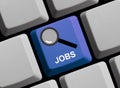 Magnifier Icon on blue computer keyboard - Find Jobs Royalty Free Stock Photo