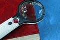 Magnifier lies on a red book on  table Royalty Free Stock Photo