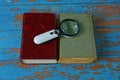 Magnifier lies on two books with a red and green cover