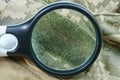 magnifier magnifies green velcro on spotted clothes Royalty Free Stock Photo