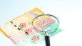 Magnifier with Malaysia bank notes.concept photo.