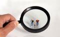 Magnifier and miniature people. The eyes of people on gay couples.