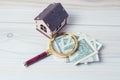 Magnifier, money and house on the table Royalty Free Stock Photo