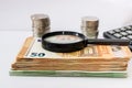 Magnifier on a stack of euro banknotes on the background of a calculator and coins. Close-up. Concept of savings or economy Royalty Free Stock Photo