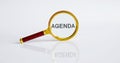 Magnifier with text AGENDA on the white background Royalty Free Stock Photo