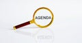Magnifier with text AGENDA on the white background Royalty Free Stock Photo