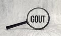 On the magnifier is the text GOUT on white background Royalty Free Stock Photo
